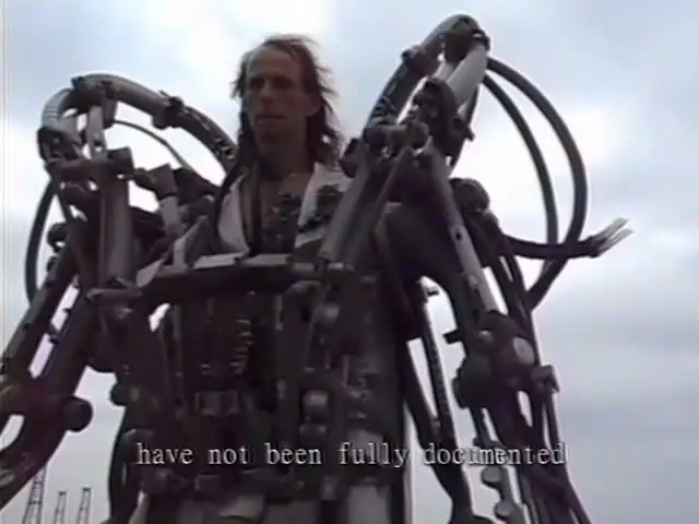 An augmented person surrounded by a large mechanical support structure.